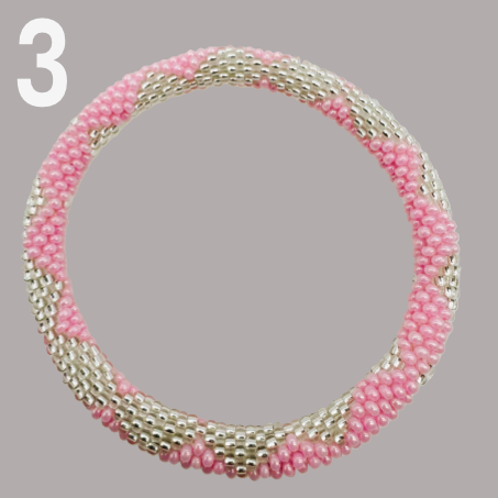 A selection of beaded bracelets in shades of pink, handmade from Nepal.