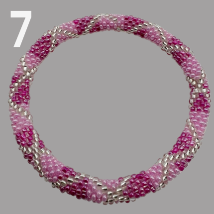 A selection of beaded bracelets in shades of pink, handmade from Nepal.